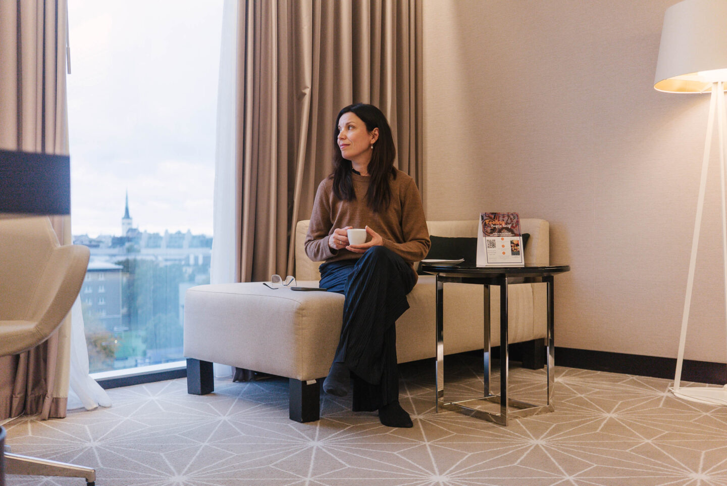 Bloggaaja istuu hotellihuoneessa ikkunan ääressä teekuppi kädessään