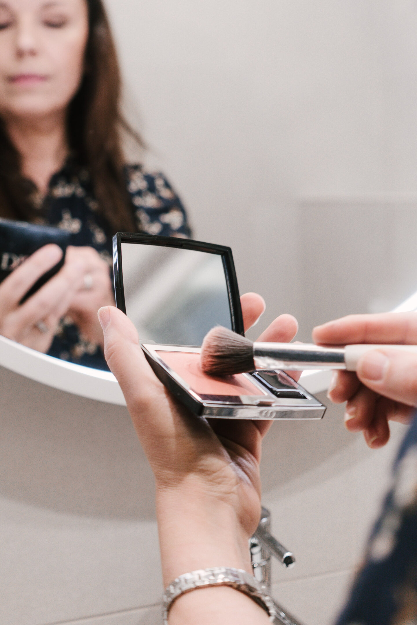 Lähikuva bloggaajan kädessä olevasta Diorin poskipunapaletista ja siveltimestä