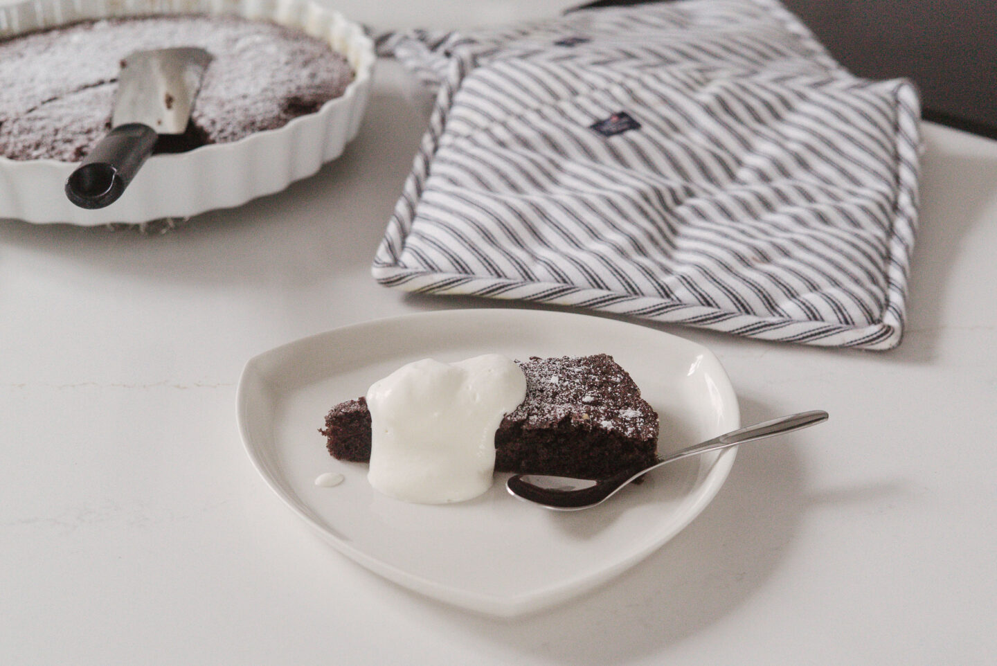 Pala mutakakkua on nostettu lautaselle ja päälle on laitettu nokare kermavaahtoa